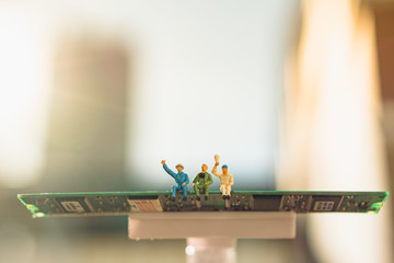 Naklejka na ściany i meble Miniature people group of man sitting on circuit board