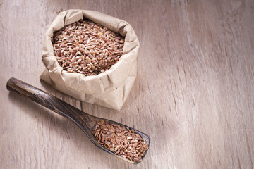 Flax seeds in wooden bowl and spoon