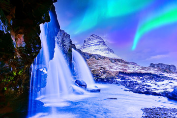 View of the northern light at dusk over Kirkjufell Mountain in Iceland.