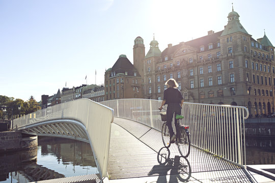 Woman biking over bridge