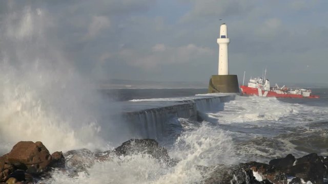 Oil support vessel entering Aberdeen harbour, Scotland, in heavy seas