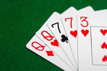 poker hand of playing cards on green casino cloth