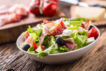 Salad. Fresh summer lettuce salad.Healthy mediterranean salad olives tomatoes parmesan cheese and prosciutto.