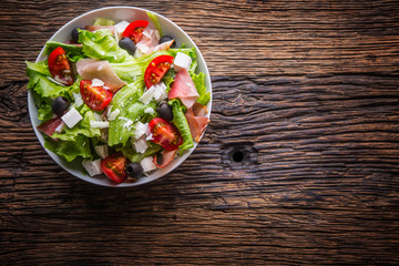 Salad. Fresh summer lettuce salad.Healthy mediterranean salad olives tomatoes parmesan cheese and prosciutto.