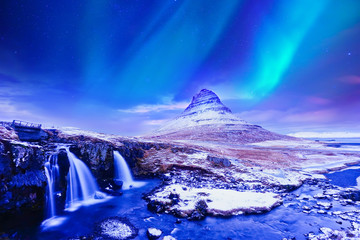 View of the northern light at dusk over Kirkjufell Mountain in Iceland.