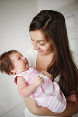 happy family. Mother and baby daughter hugging, kissing at home