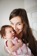happy family. Mother and baby daughter hugging, kissing at home
