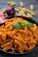 Close-up of italian fusilli pasta served with onion sauce, selective focus