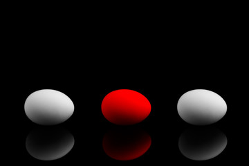 Red egg on a black background. Eggs on a black background. Other.
