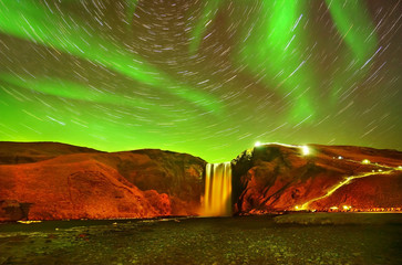 View of the northern light with star trails at Skogafoss in Iceland.