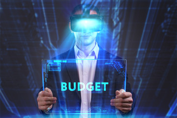 Business, Technology, Internet and network concept. Young businessman working in virtual reality glasses sees the inscription: Budget