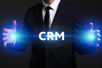 Business, Technology, Internet and network concept. Young businessman working on a virtual screen of the future and sees the inscription: CRM