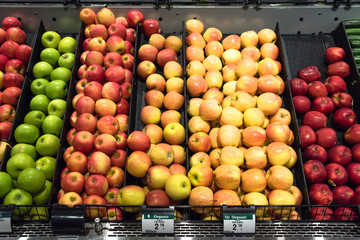 Colorful pile of fresh red, green, yellow apples for sale at local store in America. Variety of...