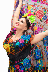 beautiful smiling mexican woman in traditional mexican dress hands up holding the skirt as a background like peacock