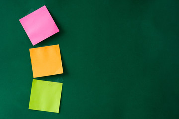 Colorful stick notes on green background. Copyspace.

