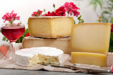 Different french cheeses with a glass of wine