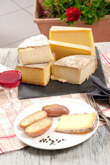 Different french cheeses with a glass of wine
