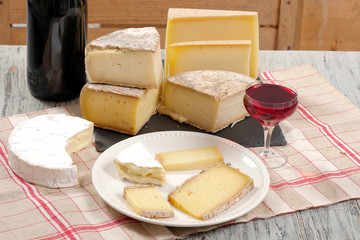 Different french cheeses with a glass of wine