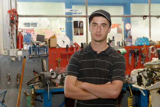 Portrait Of A Young Mechanic In His Workshop