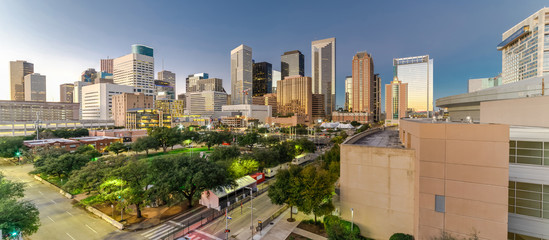 Aerial view downtown Houston illuminated at twilight with green city park and modern skylines...