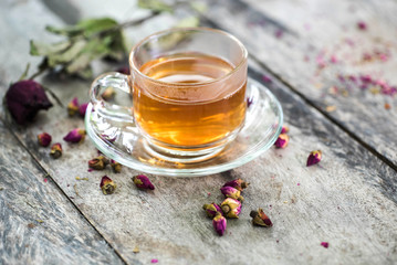 tea made from tea rose petals in a glass bowl on wooden  background