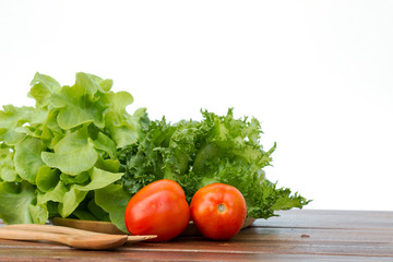 Set of salad which are tomato, Frilly Iceberg and green oak on wooden tray with spoon and fork