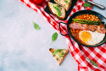 Traditional Full English Breakfast with Eggs, Bacon, Sausage, and Baked Beans