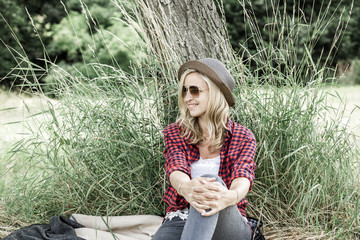young laughing woman sitting on the meadow