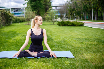 Young woman in lotus pose in the park