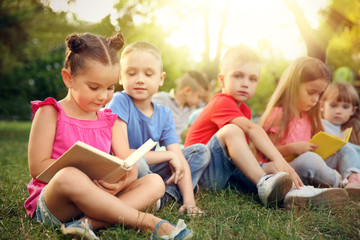 Fototapeta premium Group of happy kids reading books in park