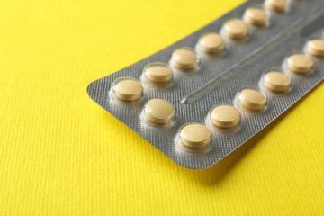 Birth pills on yellow background