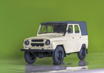 Бежевый внедорожник на зеленом фоне