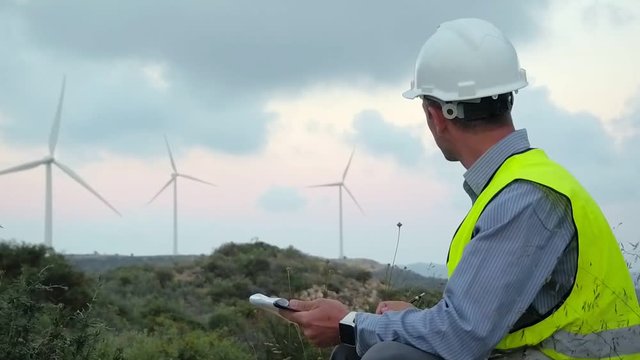 Employee of wind power makes notes during the inspection of the mill