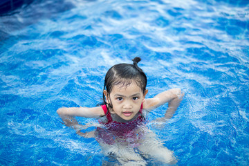 Fototapeta na wymiar Children happy to play in swiming pool