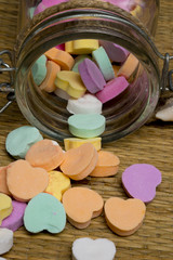 candy hearts spilling out of glass jar