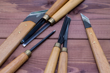Tool kit for woodcarving. Knives for carving on wooden background