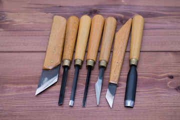 Tool kit for woodcarving. Knives for carving on wooden background