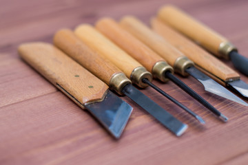 Tool kit for woodcarving. Knives for carving on wooden background