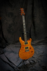 gold electric guitar on stand 