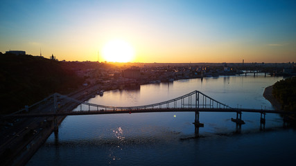 Aerial drone photo of cityscape with walk bridge and sundown