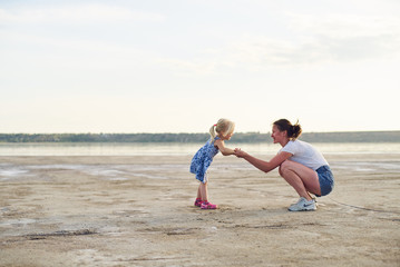 Young mother talk with her daughter on a flat ground