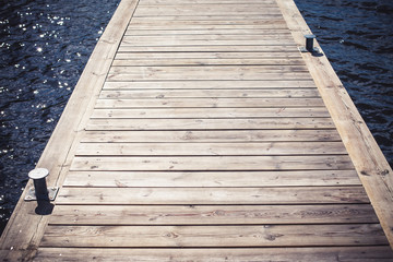 Obraz premium Wooden bridge made with desks on surface of the lake water. 