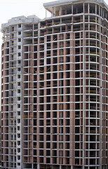 Facade and round corner of a modern concrete building under construction.