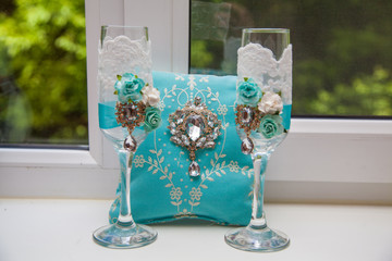 Decor wedding in turquoise. Pillow for rings with chic brooch and glasses for the newlyweds