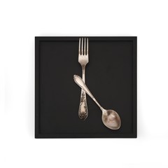 Crossed fork and spoon on a black tray