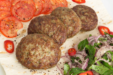 kuru kofte with fresh vegetables and herbs on flat bread