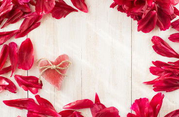 Background with paeonia petals and wooden heart
