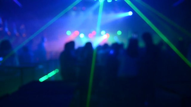   blurLight in club party Show And Silhouette hands of audience crowd people use smart phones enjoying the club party with concert. Blurry night club DJ party people enjoy of music dancing sound.