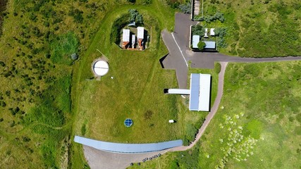 Aerial top down image of a grass roofed building