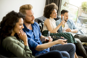 Group of friends watching TV, drinking cider and having fun